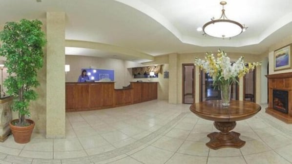 A lobby with a reception desk, a large vase with flowers, and a chandelier. - Holiday Inn Express Hotel & Suites Kerrville by IHG (Kerrville)
