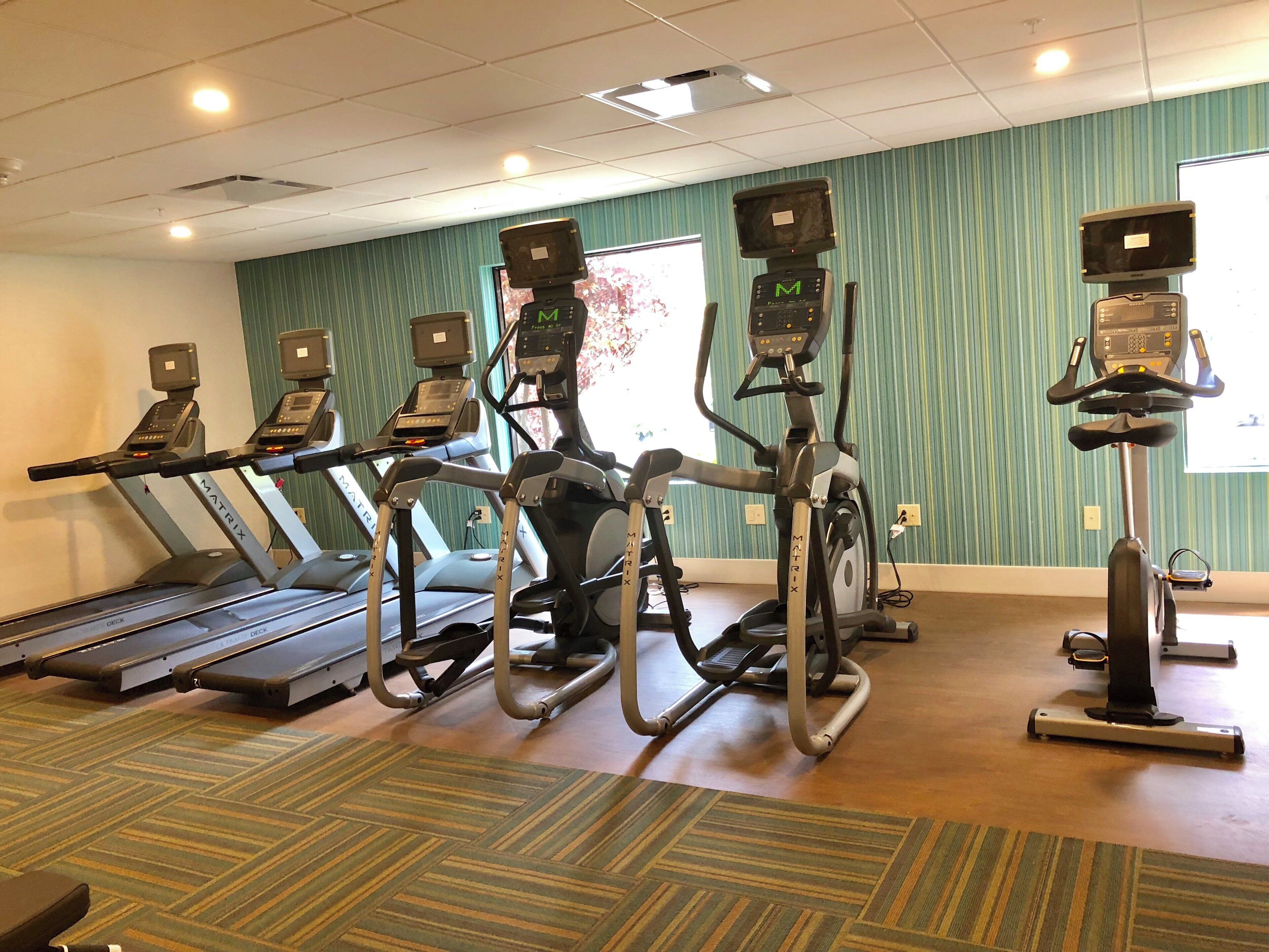 A fitness center with treadmills, elliptical machines, and a stationary bike.