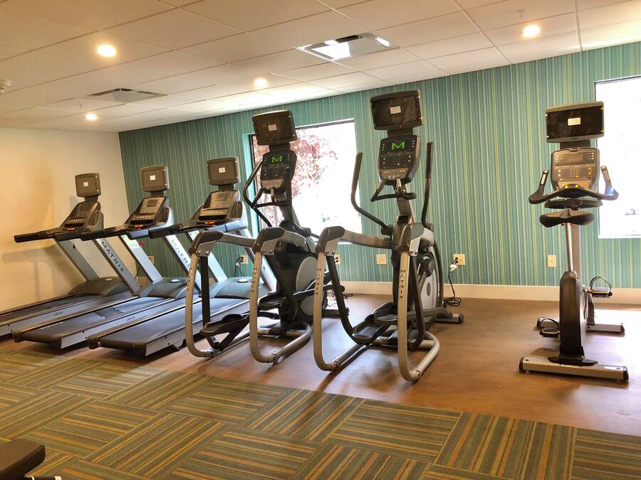 A fitness center with treadmills, elliptical machines, and a stationary bike.