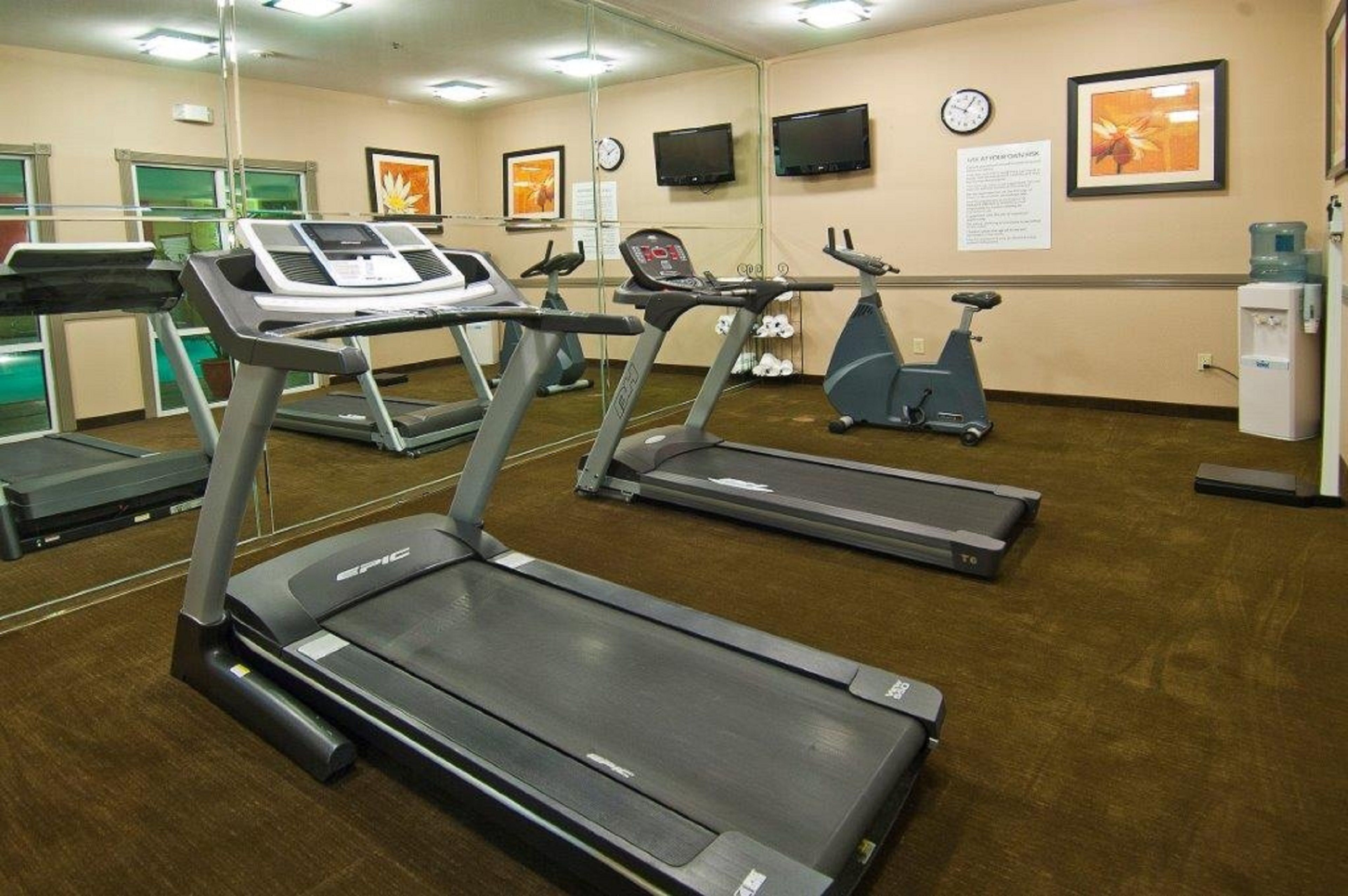 A gym with treadmills, an elliptical, and a stationary bike.