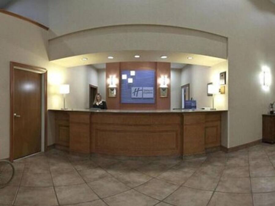 Un'area reception con un bancone in legno, una macchina per pop-corn e un cartello con il nome dell'hotel.