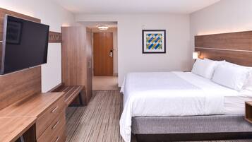 Una habitación de hotel con cama, televisión, escritorio y armario.