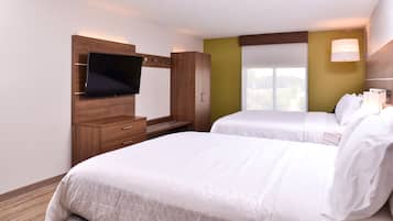 Quarto de hotel com duas camas, uma TV presa em um armário de madeira e uma janela com vista.