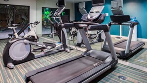 A gym with treadmills, an elliptical, and a stationary bike.