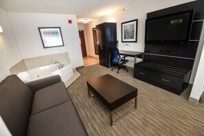 Una habitación de hotel moderna con sofá, televisión de pantalla plana, escritorio y ventana grande.