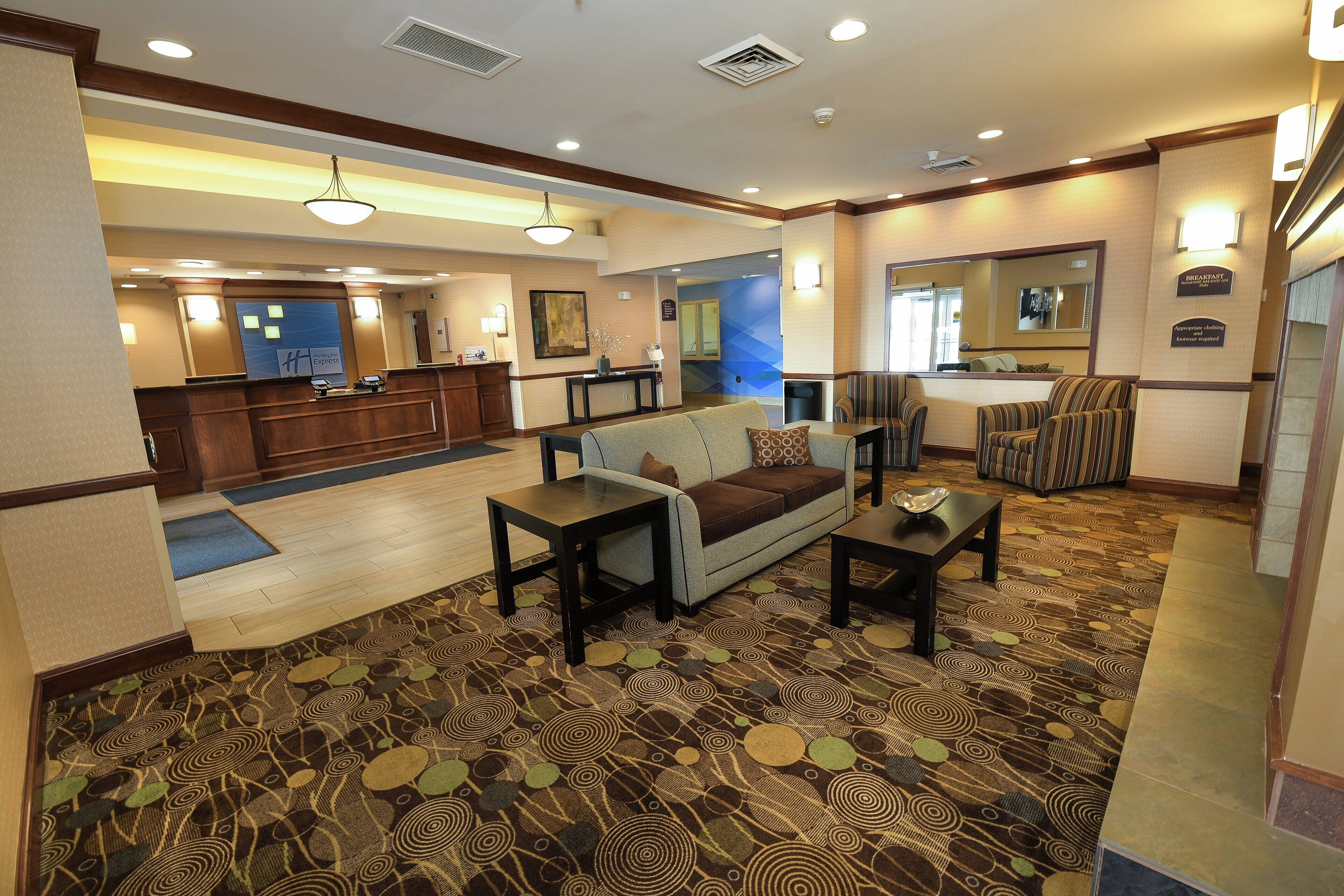 A hotel lobby with a reception desk, seating area, and a bathroom.