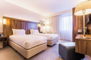 A hotel room with two beds, a desk, a lamp, and a TV. - Courtyard by Marriott Glasgow Airport (Paisley)