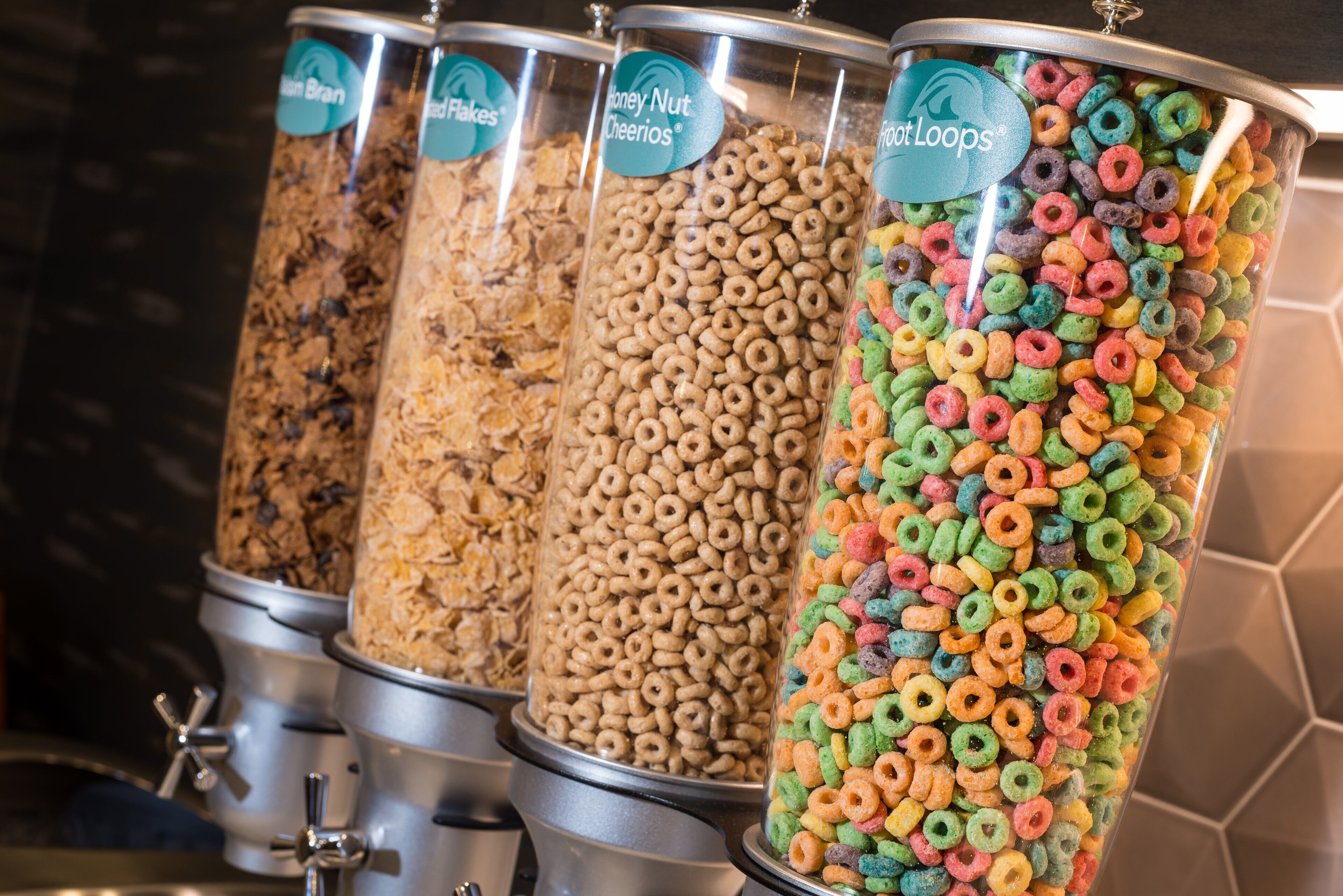 Four cereal dispensers with different brands and flavors.