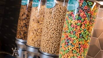 Four cereal dispensers with different brands and flavors.