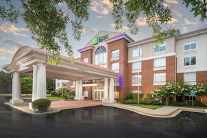 Un hotel con fachada de ladrillo, un acceso cubierto y cielo despejado.