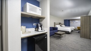 A hotel room with a kitchenette, a bed, a sofa, and a desk. - Holiday Inn Express Hotel & Suites Atlanta Johns Creek by IHG (Suwanee)