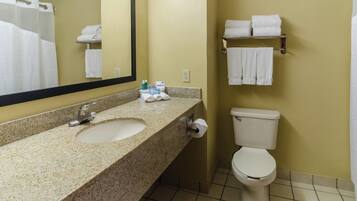 A bathroom with a sink, mirror, toilet, and towel rack.