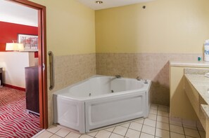 Un baño con una bañera grande, un lavabo y un espejo.