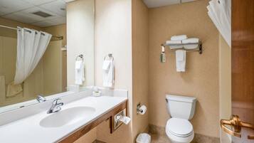 A bathroom with a sink, mirror, toilet, and towel rack.