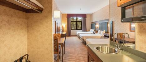A hotel room with a kitchenette, a dining area, and a large window.