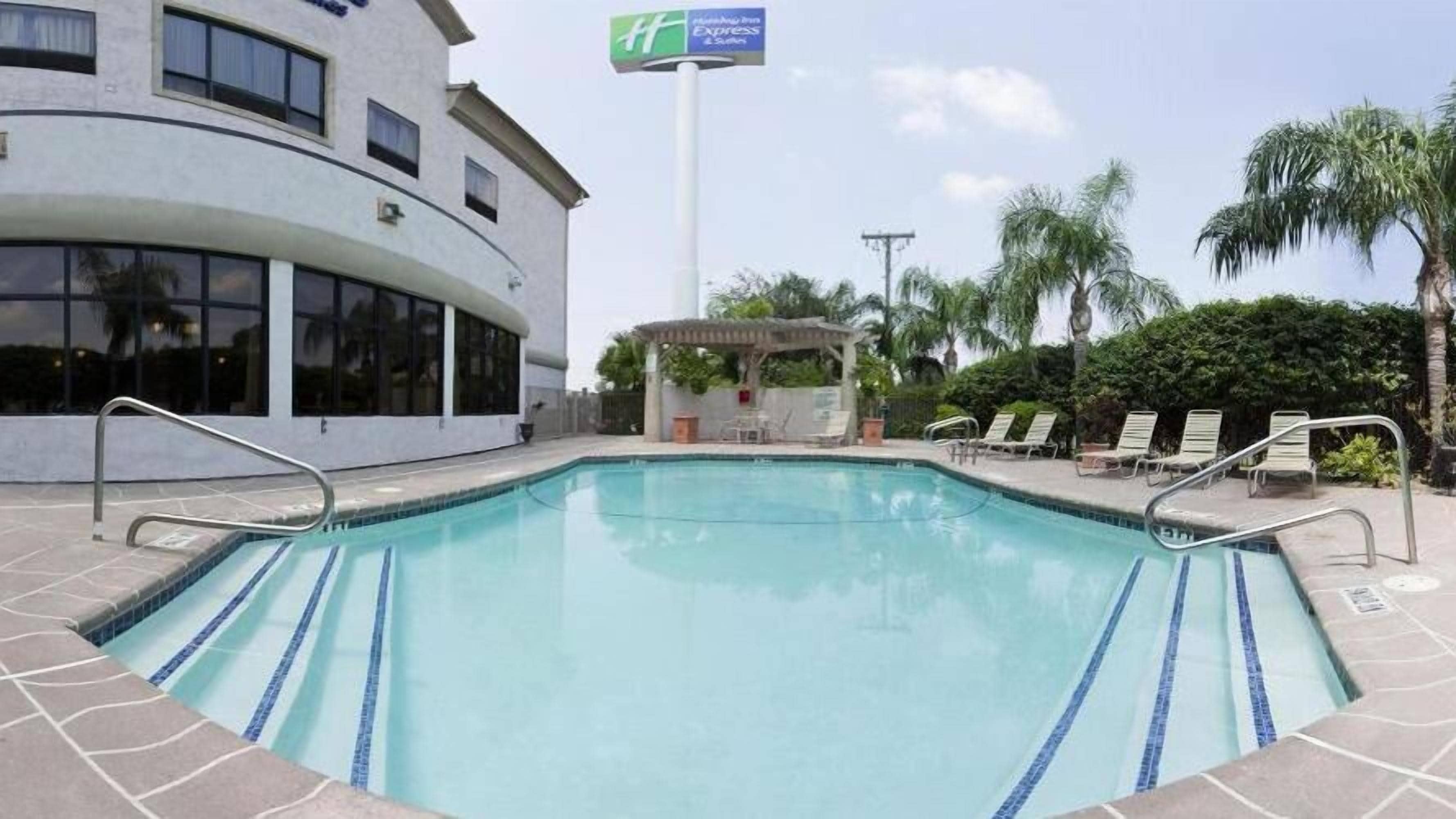 Area piscina con sedie a sdraio e gazebo.