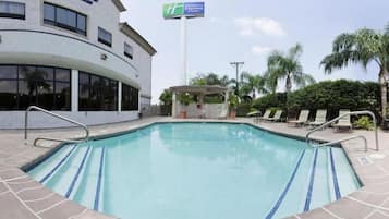Area piscina con sedie a sdraio e gazebo.