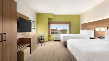 Una habitación de hotel con una cama, un escritorio, una silla, un televisor y una ventana.