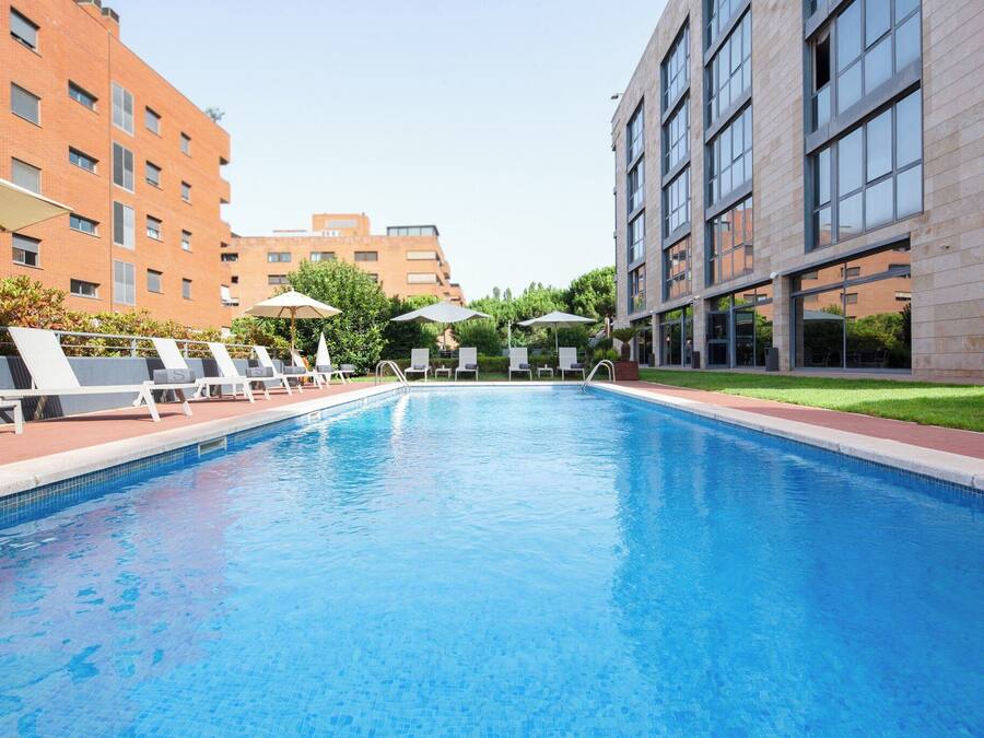 Una piscina al aire libre de temporada, sombrillas, tumbonas