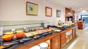 A buffet with various food items and utensils. - Sercotel Cornella Barcelona (Cornella de Llobregat)