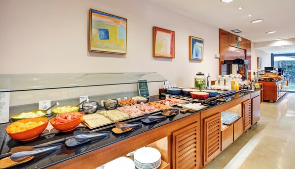 A buffet with various food items and utensils. - Sercotel Cornella Barcelona (Cornella de Llobregat)