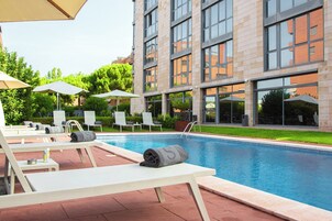 Una piscina al aire libre de temporada, sombrillas