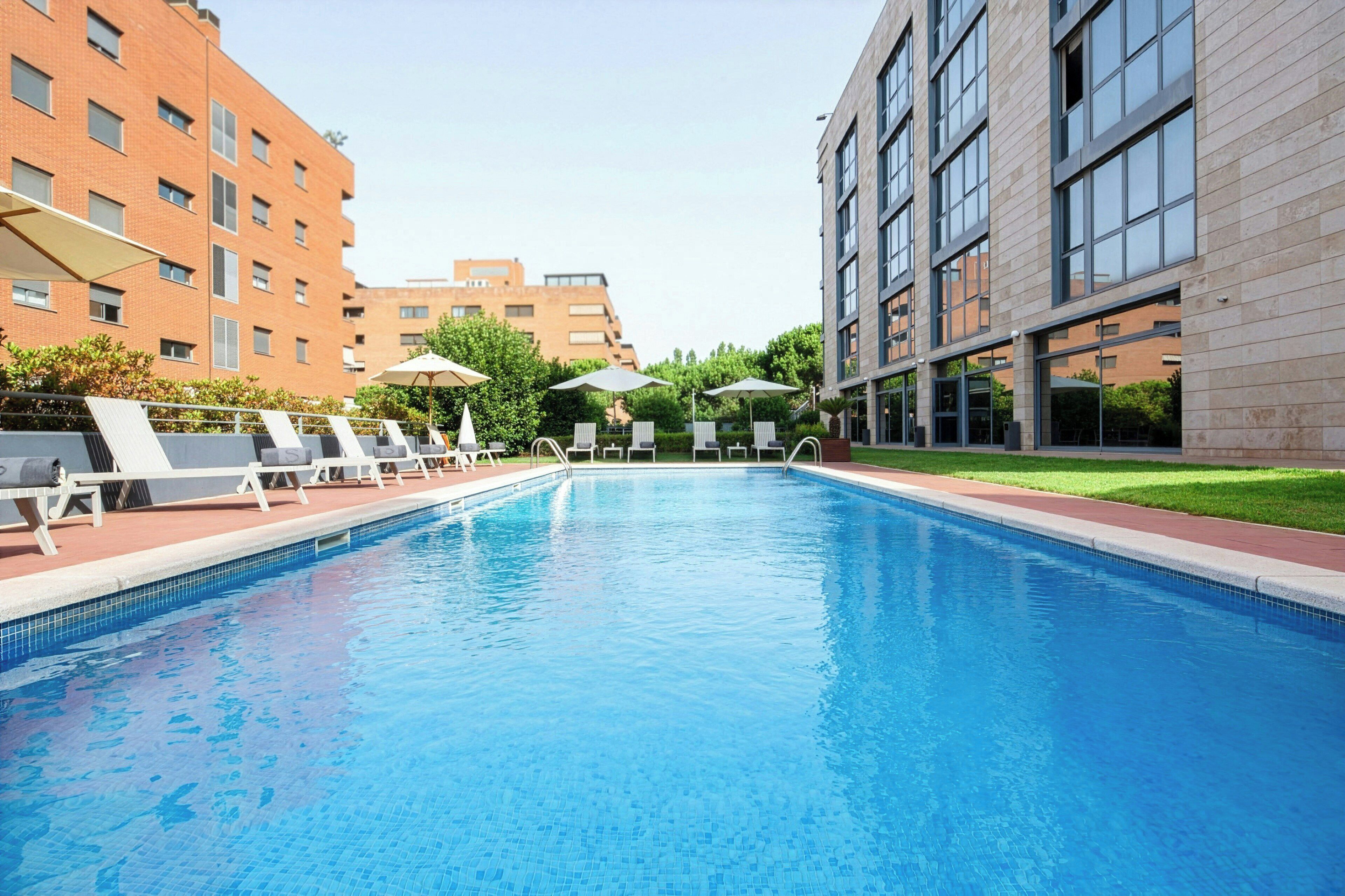 Una piscina al aire libre de temporada, sombrillas, tumbonas