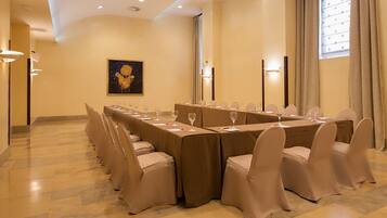 Una sala de conferencias con una mesa grande, sillas y un cuadro en la pared.