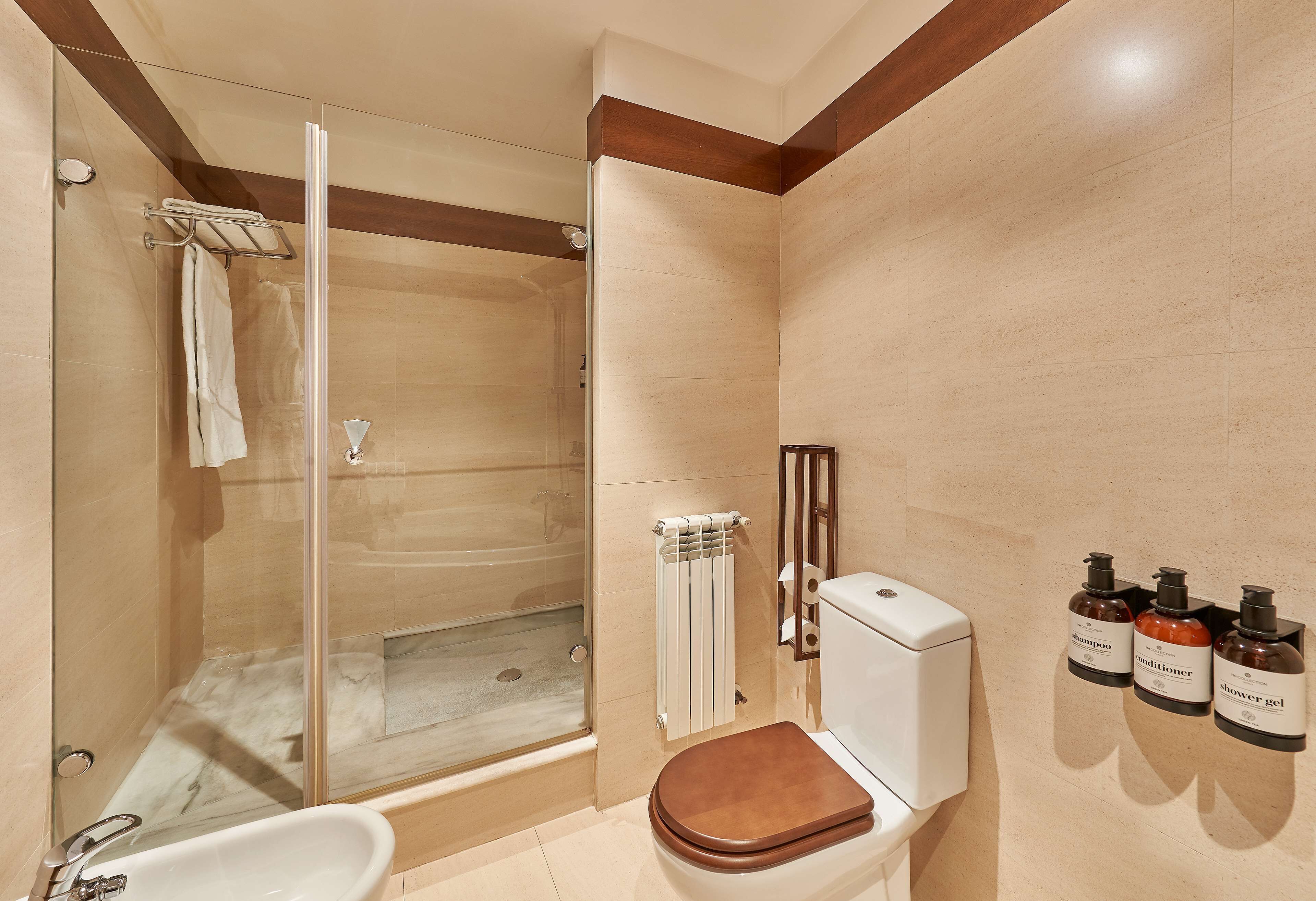 Un baño con ducha de vidrio, inodoro blanco y bañera.