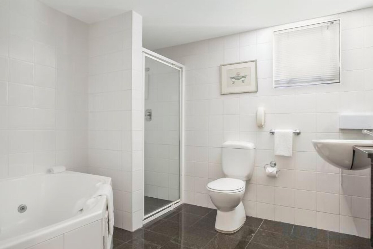 A bathroom with a shower, toilet, and bathtub.