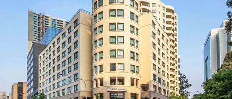 Un hôtel à plusieurs étages, doté d’une façade incurvée, de grandes fenêtres et d’une enseigne indiquant « mantra - Parramatta ».