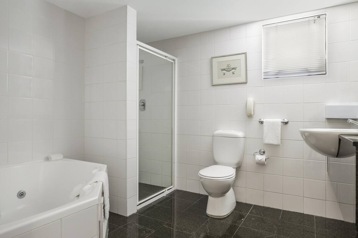 A bathroom with a bathtub, toilet, and sink.