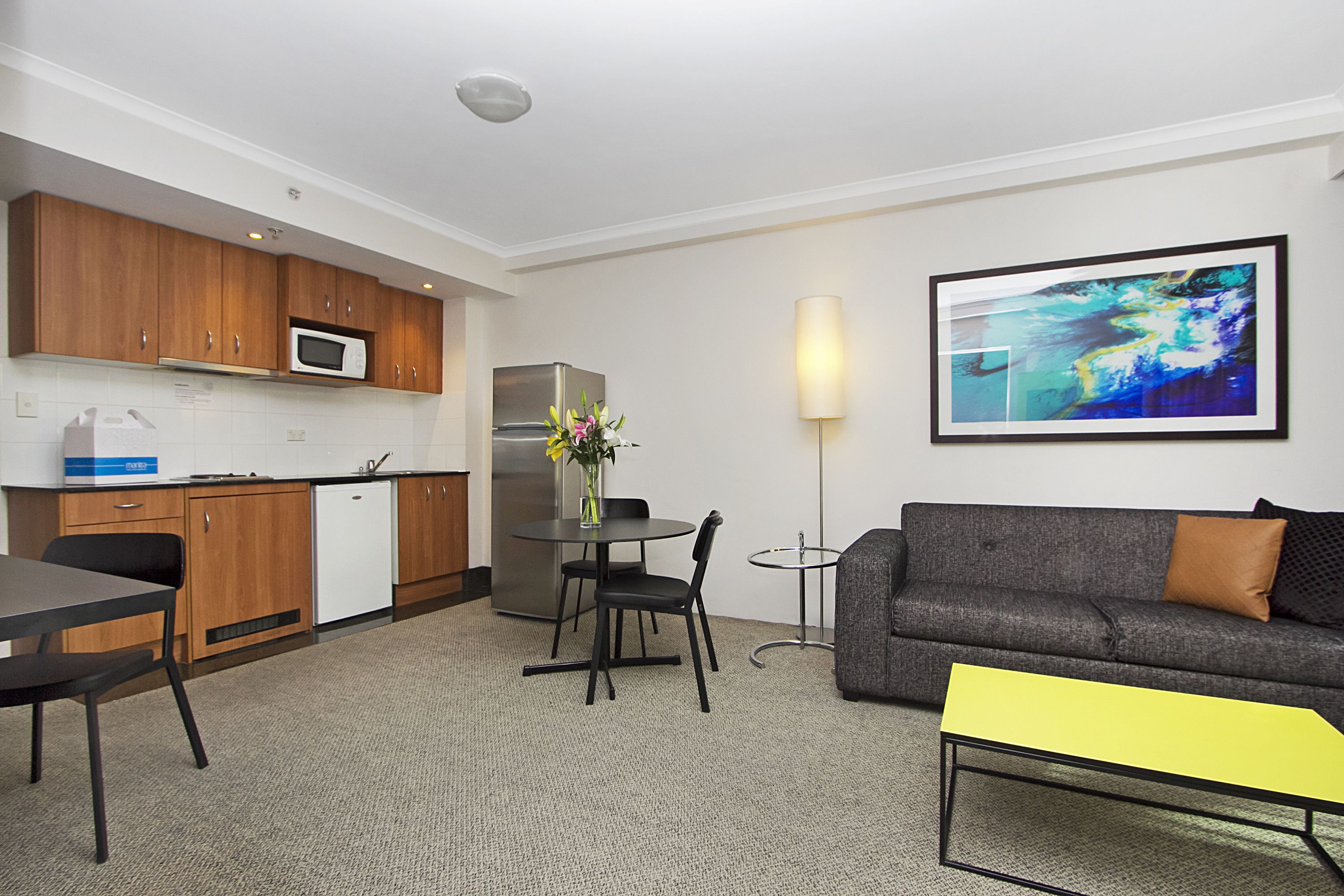 A compact living space with a kitchenette, dining area, and seating area.