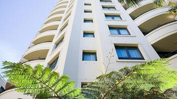 A high-rise building with multiple balconies and windows.