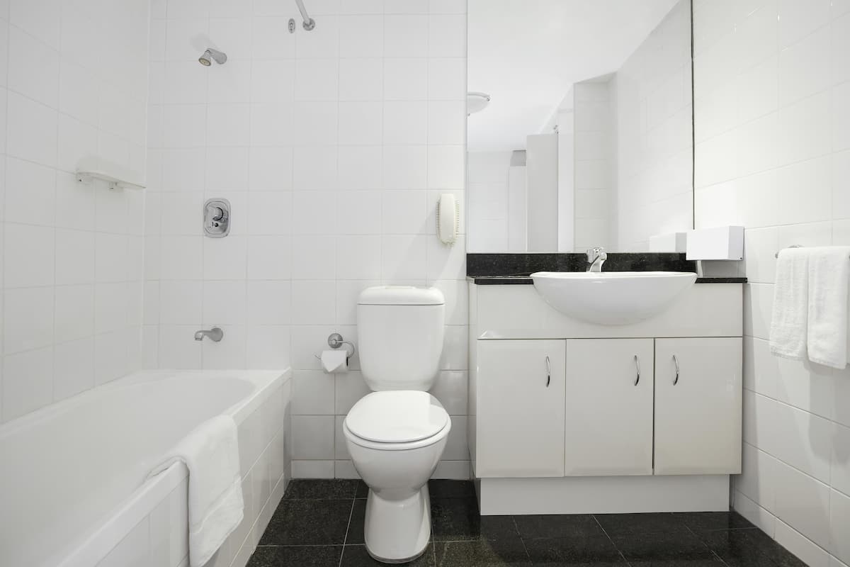 A modern bathroom with a toilet, bathtub, and sink.