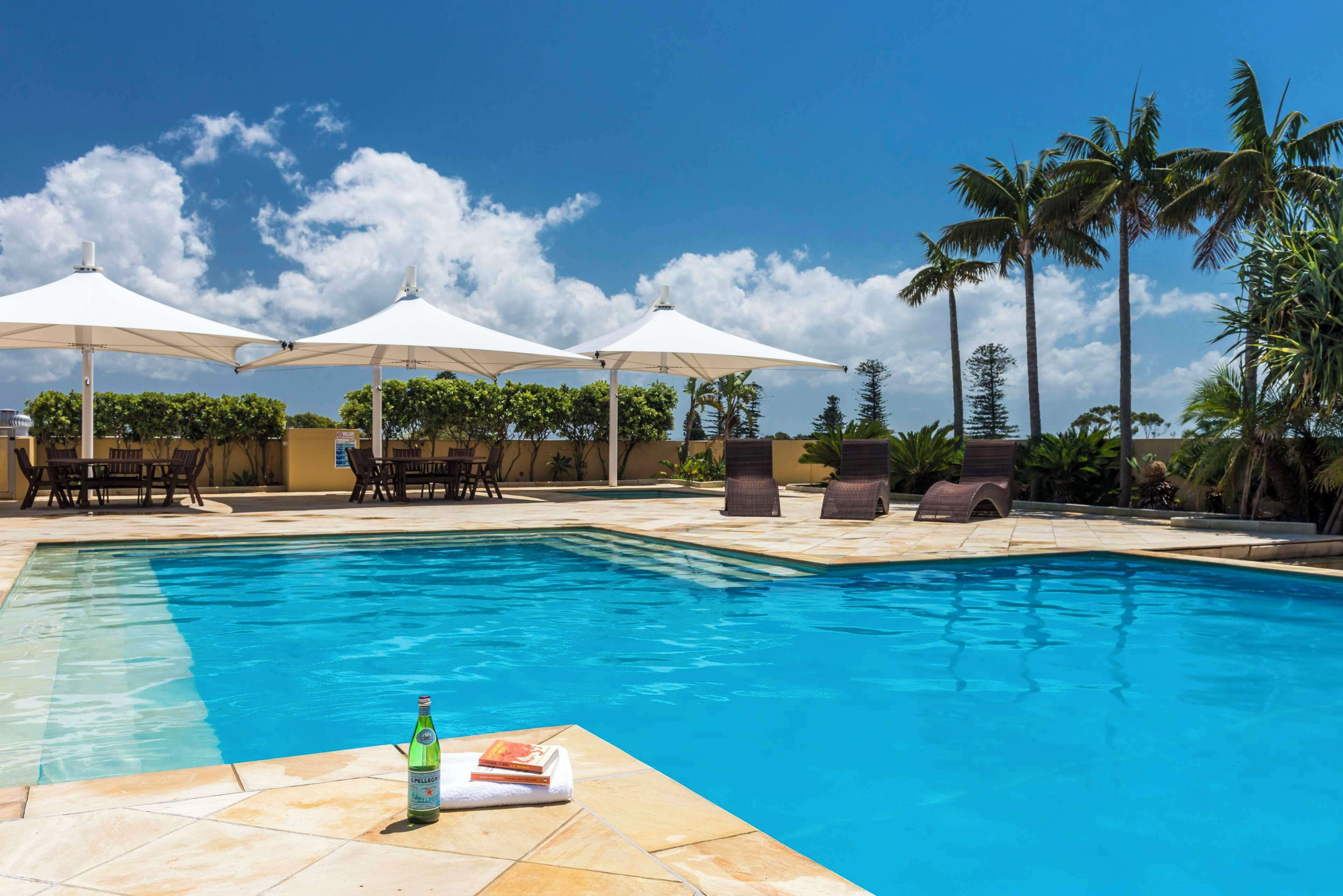 Utomhuspool, parasoller och solstolar