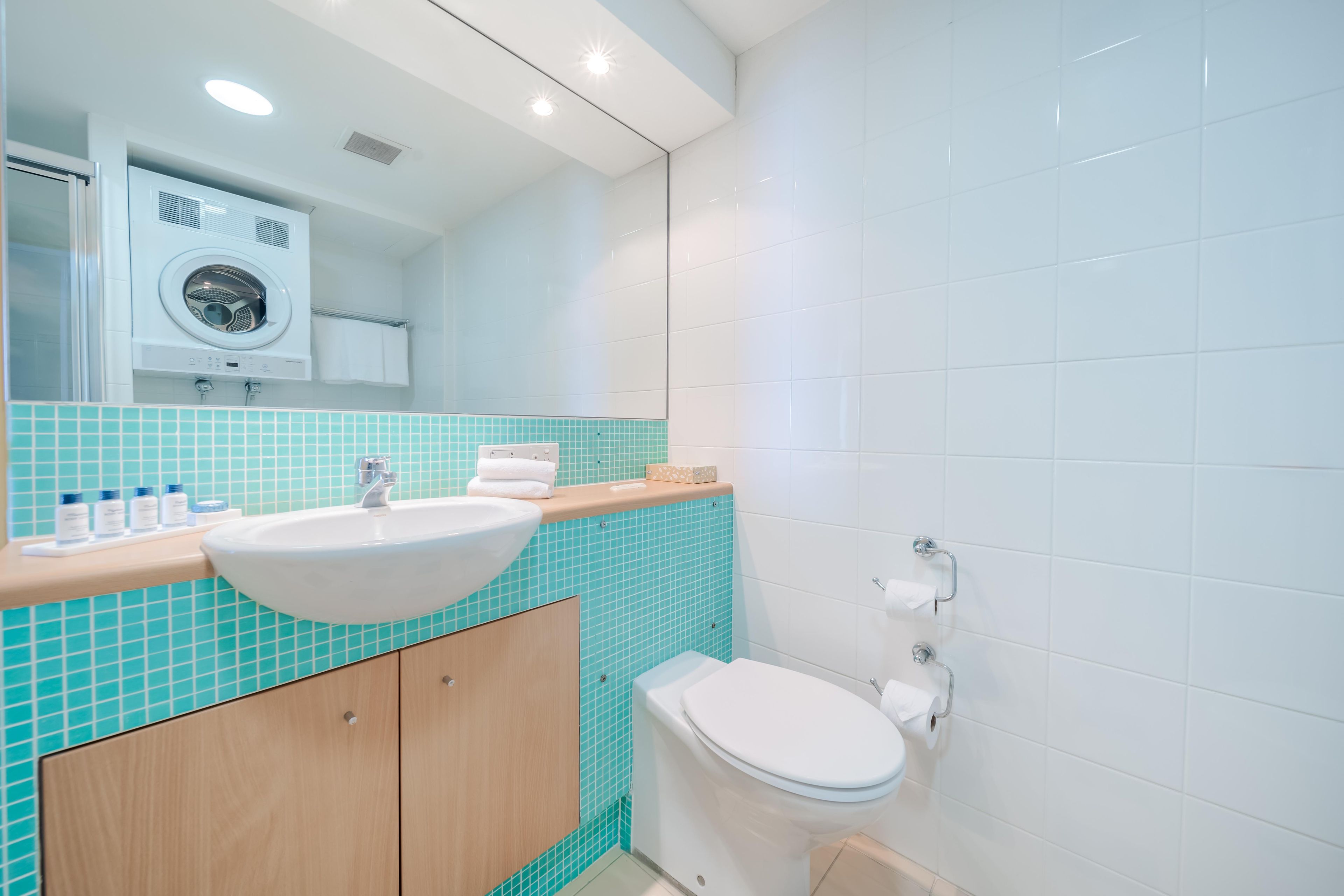 Ein modernes Badezimmer mit Waschbecken, Spiegel und Toilette.