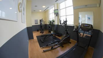 A gym with exercise equipment, a treadmill, and a large window.