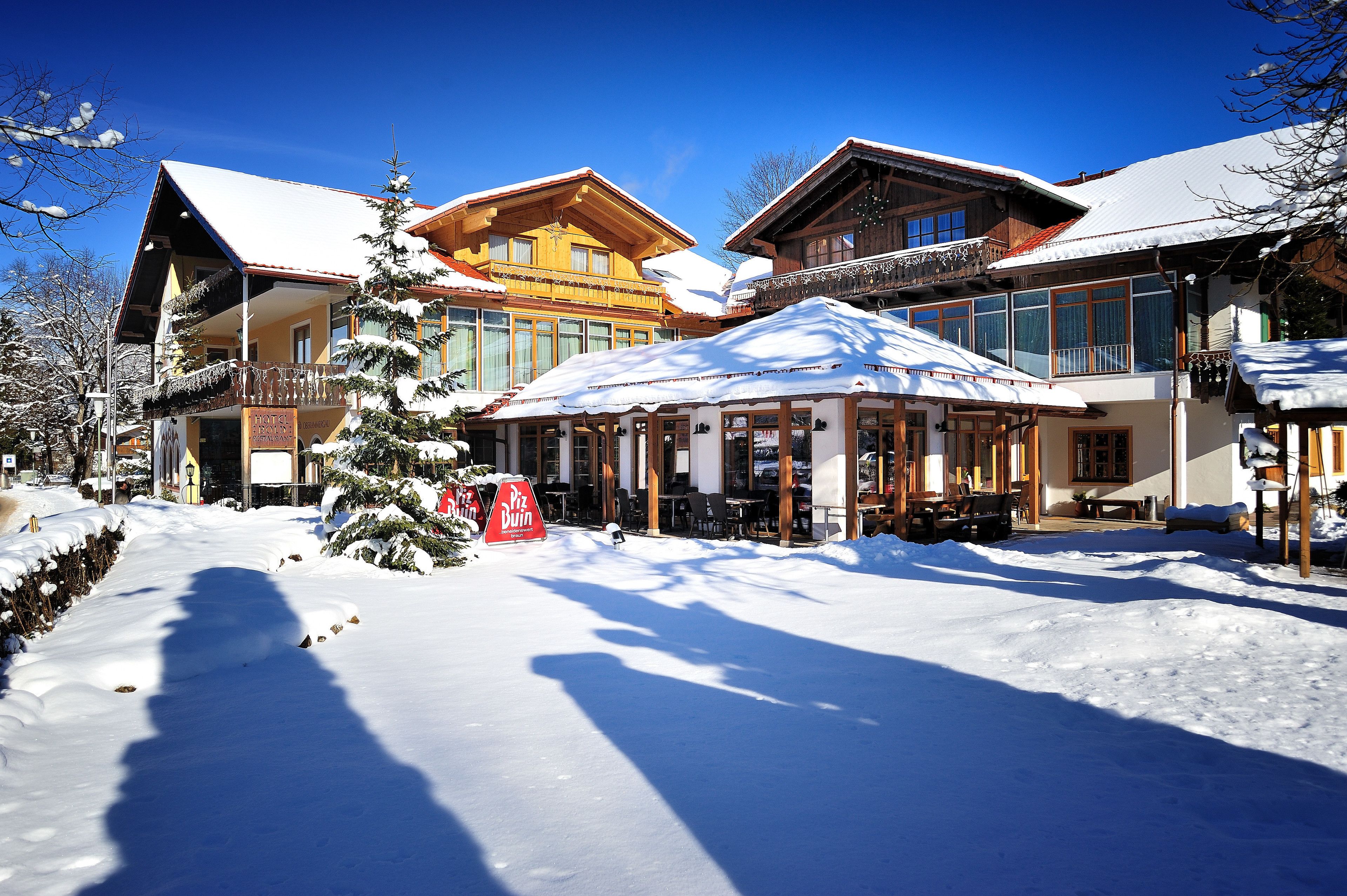 Ein schneebedecktes Gebäude mit großen Fenstern und einem Balkon.