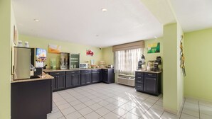 A spacious kitchen with dark cabinets, a large island, and a built-in refrigerator. - Quality Inn Clovis (Clovis)