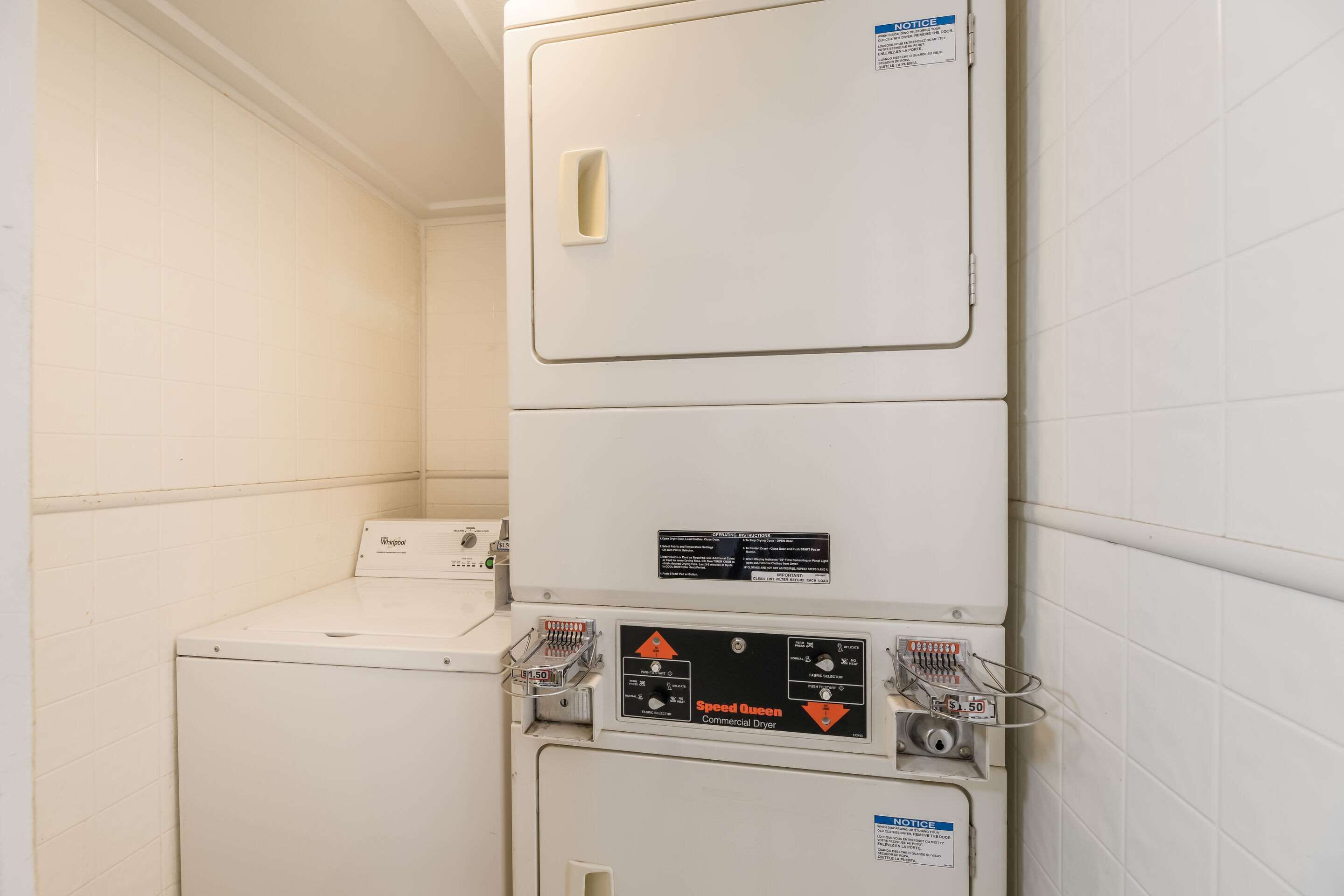 A stacked washer and dryer unit in a laundry room with a control panel labeled "Speed Queen Commercial Dryer."