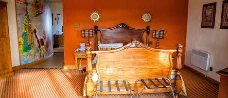 A bedroom with a wooden bed, two wall-mounted lamps, a large painting on the wall, and a checkered floor.