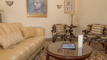A living room with a sofa, two armchairs, a coffee table, and decorative wall art.