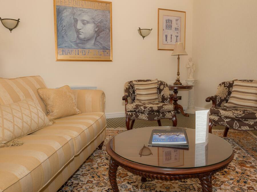 A living room with a sofa, two armchairs, a coffee table, and decorative wall art.