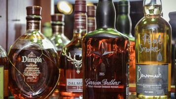 A variety of whiskey bottles on a shelf.