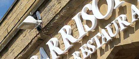 A building with a sign that reads "THE GARRISON GARDENHOUSE & RESTAURANT".
