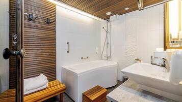 Un baño moderno con un banco de madera, una bañera, una ducha y un lavabo.
