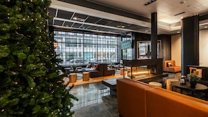 Un vestíbul modern amb un gran arbre de Nadal, zones d'estar i grans finestres.
