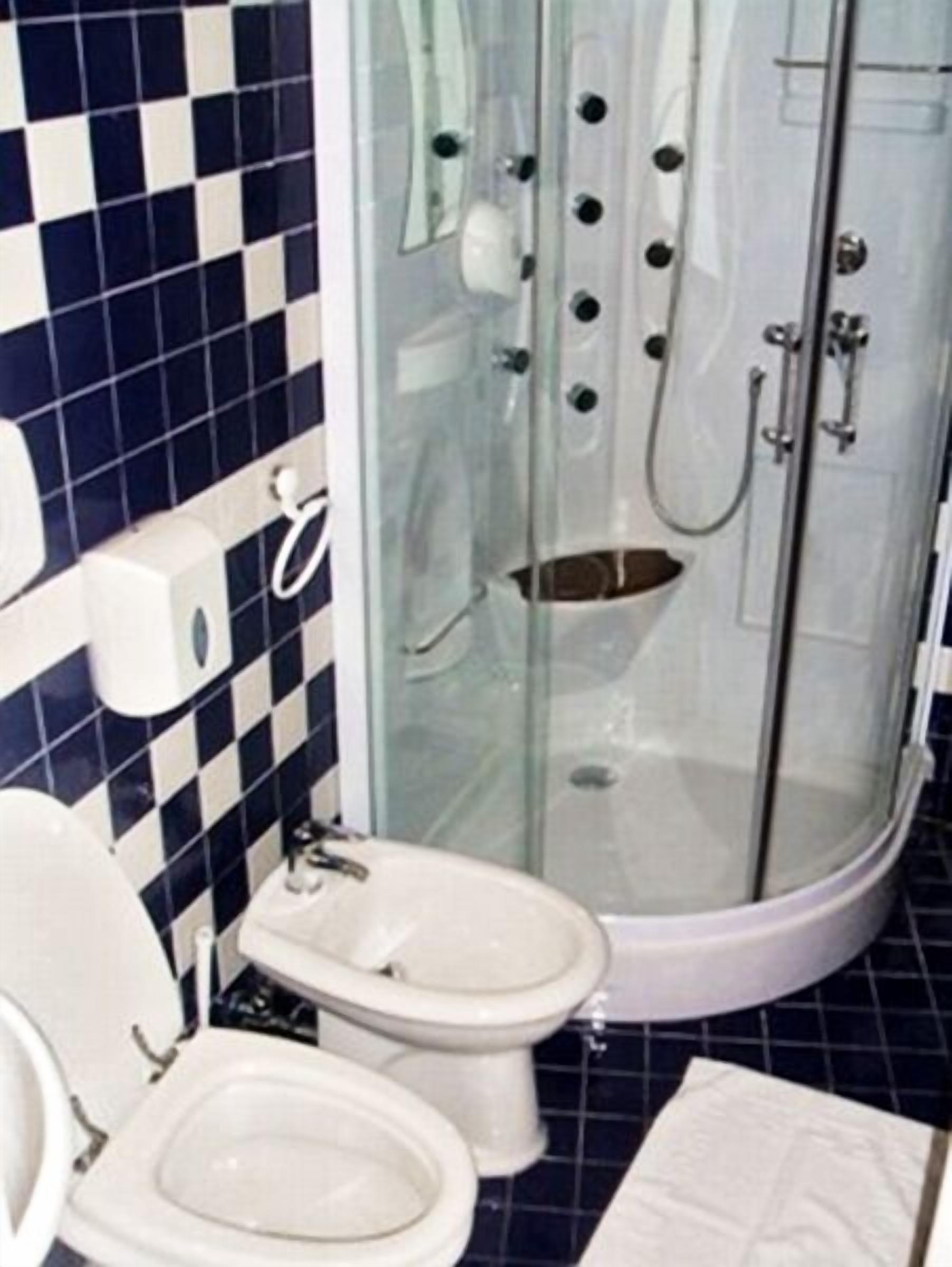 Un baño con ducha de vidrio, inodoro y bidé.