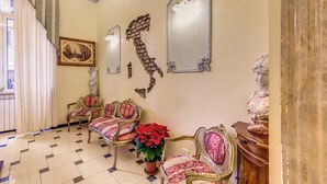 A room with ornate furniture, a potted plant, and decorative mirrors. - Hotel Cambridge (Rome)